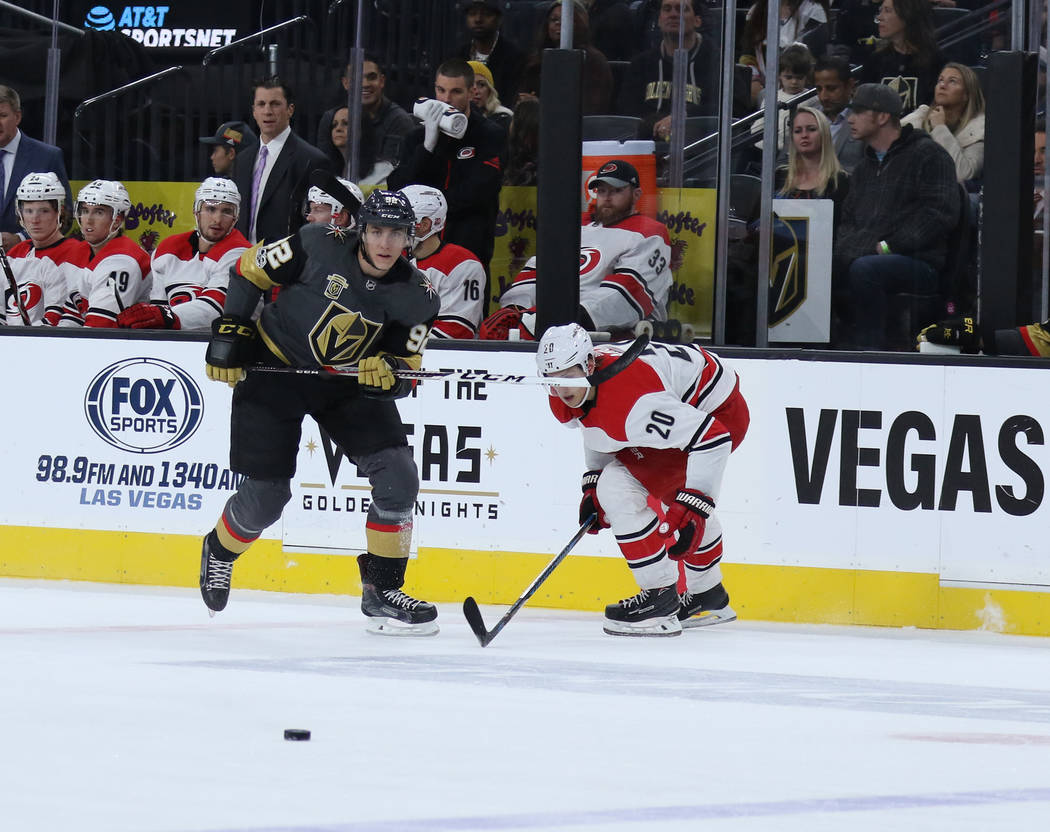 Vegas Golden Knights left wing Tomas Nosek (92) and Carolina Hurricanes right wing Sebastian Aho (20) skate towards the puck during the first period of a NHL game in Las Vegas, Tuesday, Dec. 12, 2 ...
