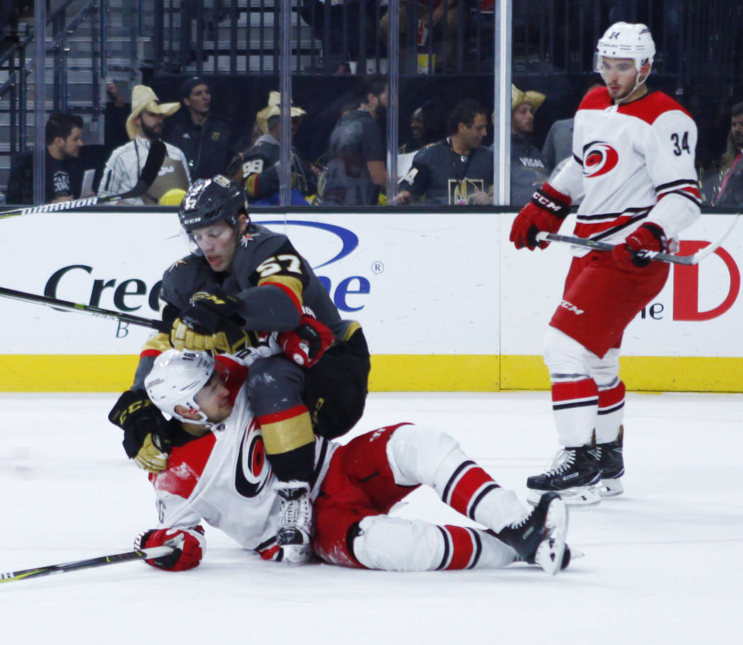 Vegas Golden Knights left wing David Perron (57) and Carolina Hurricanes center Marcus Kruger (16) engage in a tussle during the first period of a NHL game in Las Vegas, Tuesday, Dec. 12, 2017. He ...