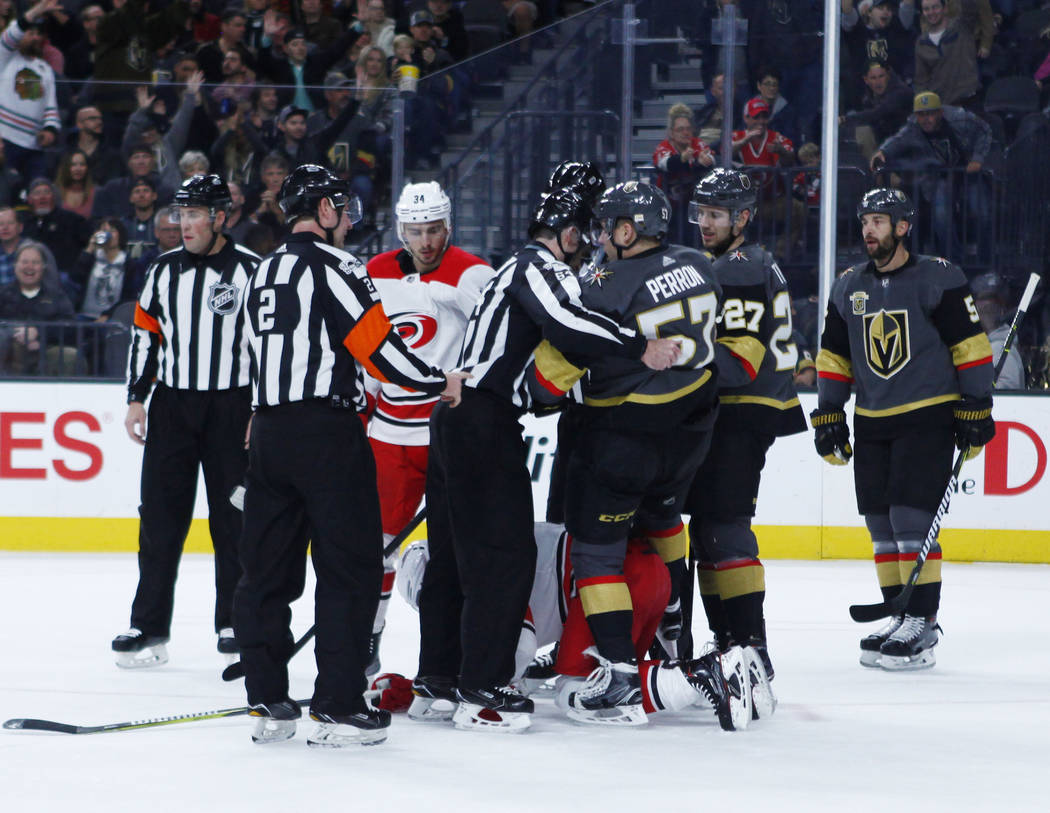 Referees break up a tussle between Vegas Golden Knights left wing David Perron (57) and Carolina Hurricanes center Marcus Kruger (16) during the first period of a NHL game in Las Vegas, Tuesday, D ...
