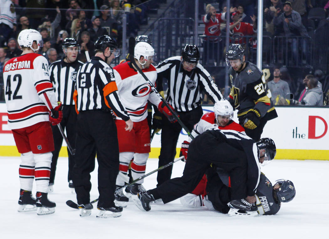 Referees break up a tussle between Vegas Golden Knights left wing David Perron (57) and Carolina Hurricanes center Marcus Kruger (16) during the first period of a NHL game in Las Vegas, Tuesday, D ...