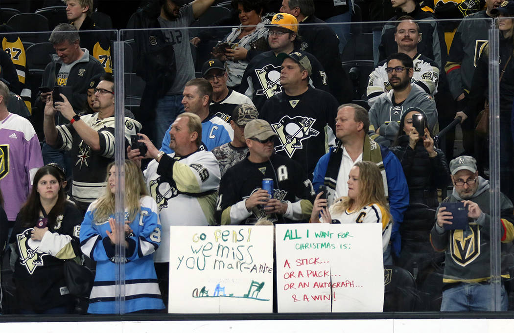Pittsburgh Penguins fans hold up signs, one for Vegas Golden Knights goalie Marc-Andre Fleury (29), not pictured, prior to the start of NHL game at the T-Mobile Arena in Las Vegas, Thursday, Dec. ...