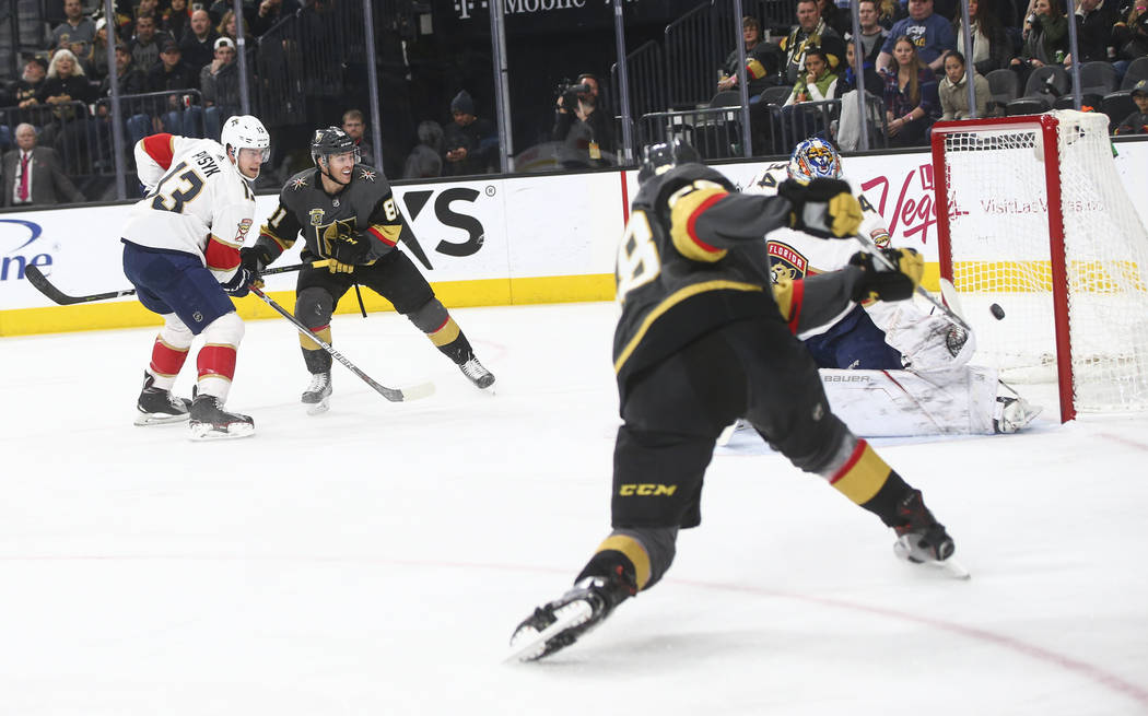 Golden Knights' Nate Schmidt (88) sends the puck in past Florida Panthers goalie James Reimer (34) against the Florida Panthers during an NHL hockey game at T-Mobile Arena in Las Vegas on Sunday,  ...