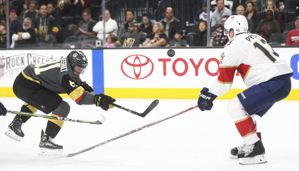 The puck flies in the air between Golden Knights' Jonathan Marchessault (81) and Florida Panthers' Mark Pysyk (13) during an NHL hockey game at T-Mobile Arena in Las Vegas on Sunday, Dec. 17, 2017 ...