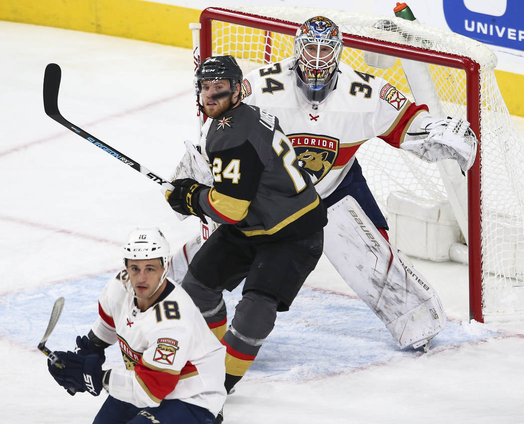 Golden Knights' Oscar Lindberg (24) and Florida Panthers goalie James Reimer (34) watch the puck fly by during an NHL hockey game at T-Mobile Arena in Las Vegas on Sunday, Dec. 17, 2017. Chase Ste ...