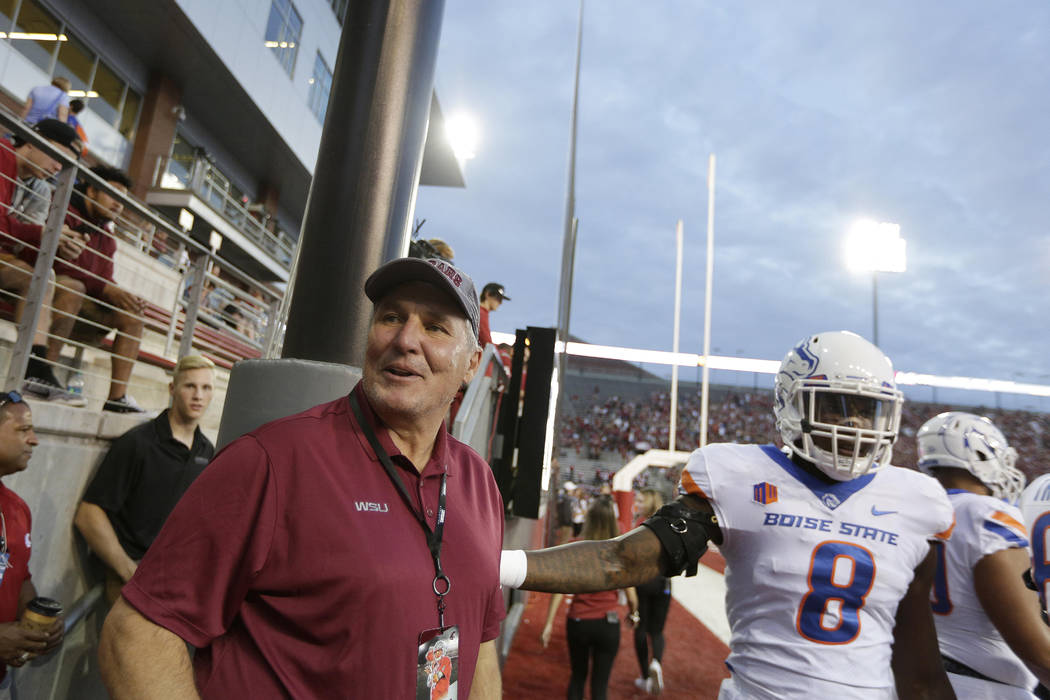 Former NFL Washington Redskins and Washington State quarterback Mark Rypien,  left, stands on the field before an NCAA college football game between  Washington State and Boise State in Pullman, Was …