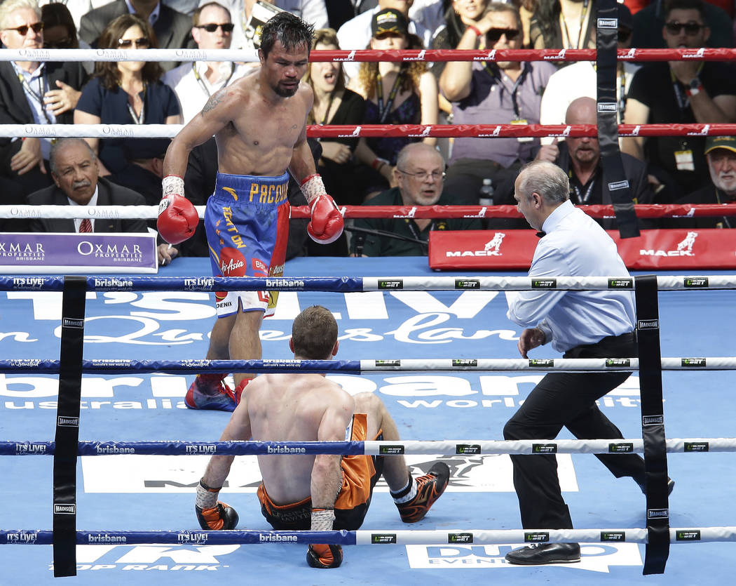 Manny Pacquiao, right, of the Philippines watches Jeff Horn of Australia falls on the mat during their WBO World welterweight title bout in Brisbane, Australia, Sunday, July 2, 2017. Pacquiao lost ...