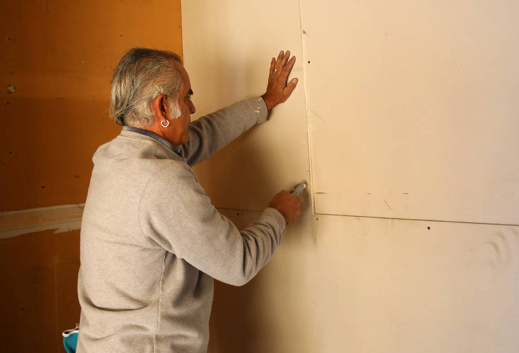 Mike Martinez installs drywall at the Las Vegas home of 87-year-old U.S. Air Force veteran Louise Jones Tuesday, Dec. 12, 2017. Rebuilding Together, a nationwide non-profit organization, coordinat ...
