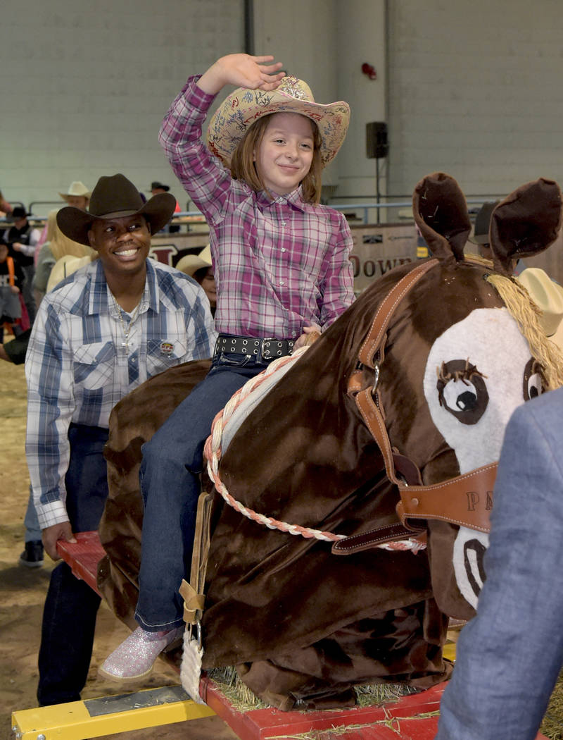 Nadia Wiggins makes his 8 seconds on her bareback ride as special needs children experience the world of rodeo with Wrangler NFR contestants, announcers, personnel and even Miss Rodeo America at T ...