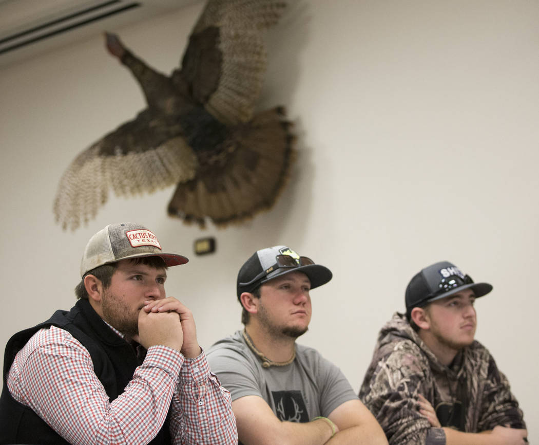Gabe Lopez, from left, Jay Gilbert, and Cody Bronson, of Ely, Nev., listen during an orientation at the Clark County Shooting Complex for hunters randomly picked for the annual bighorn sheep hunt  ...