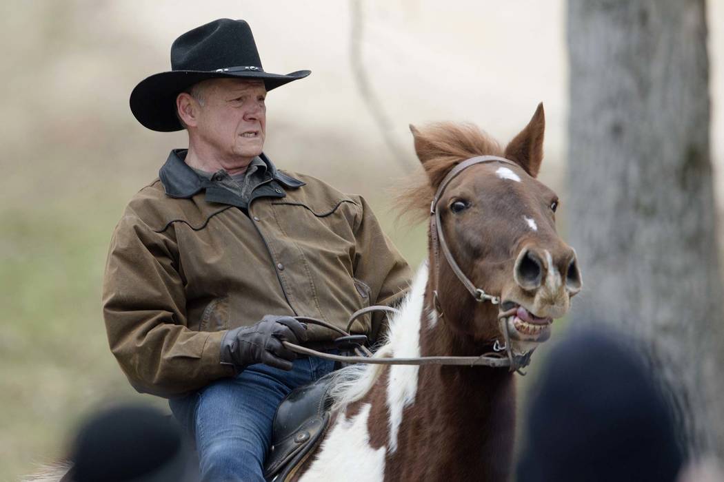 Republican senate nominee Roy Moore rides a horse to a polling station to cast his ballot in Alabama's special Senate election, Tuesday, Dec. 12, 2017, in Gallant, Ala. (Albert Cesare/The Montgome ...