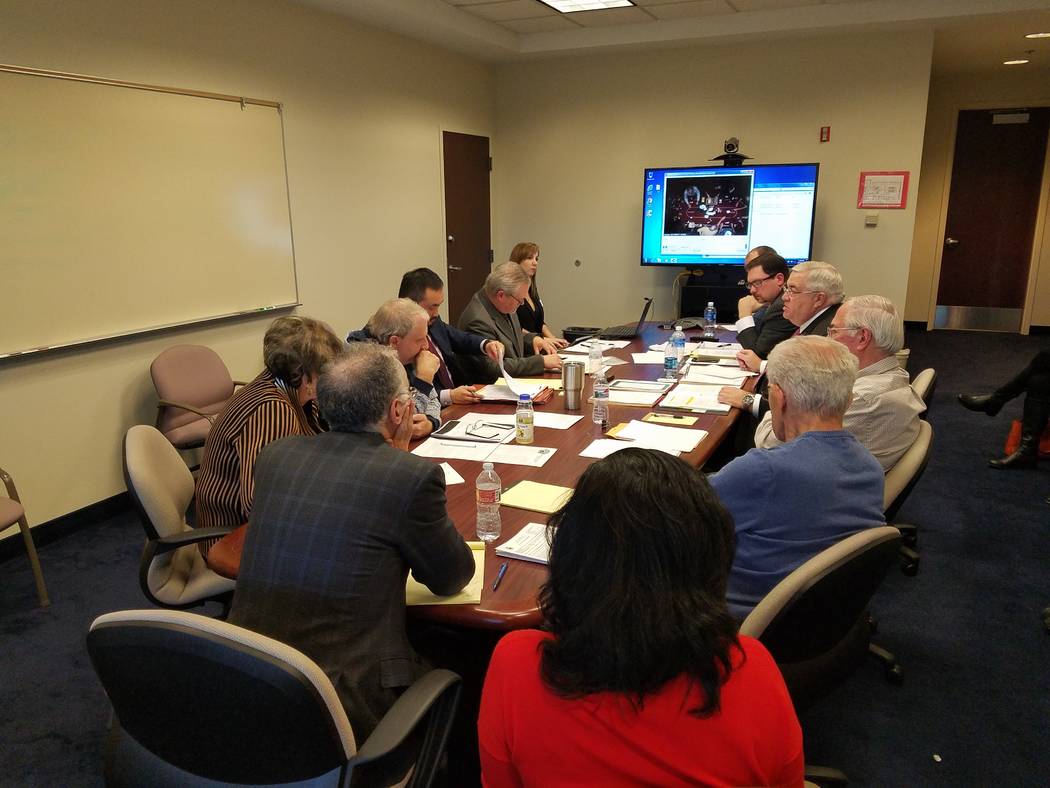 Poker players, Station Casinos' poker room officials and state Gaming Control Board administrators gather around a table in a conference room at the Gaming Control Board offices at the Sawyer Buil ...