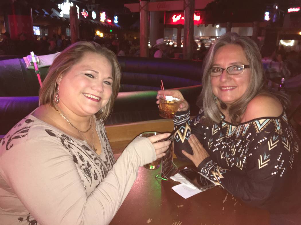 Jamie Holeman, left, and Michele Thornhill raise a toast Tuesday night during the Wrangler National Finals Rodeo viewing party at Gilley's, inside Treasure Island. Viewing parties, which feature t ...