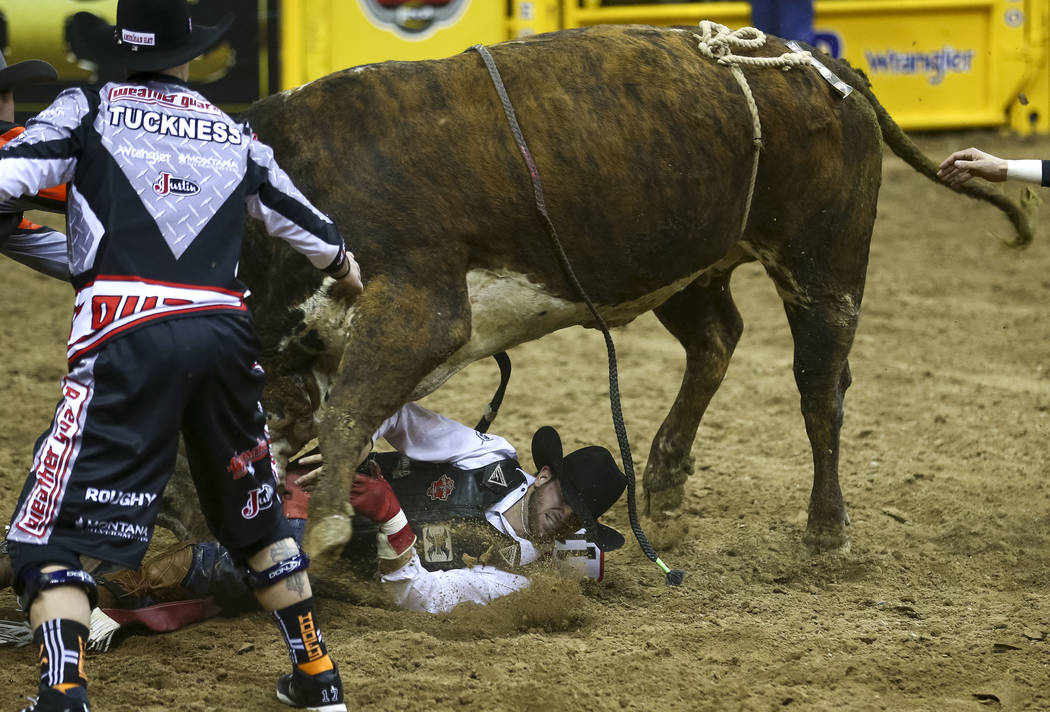 Guthrie Murray of Miami, Oklahoma is charged by Muley Maddness in the bull riding competition during the seventh go-round of the National Finals Rodeo, Wednesday, Dec. 13, 2017, at the Thomas & ...