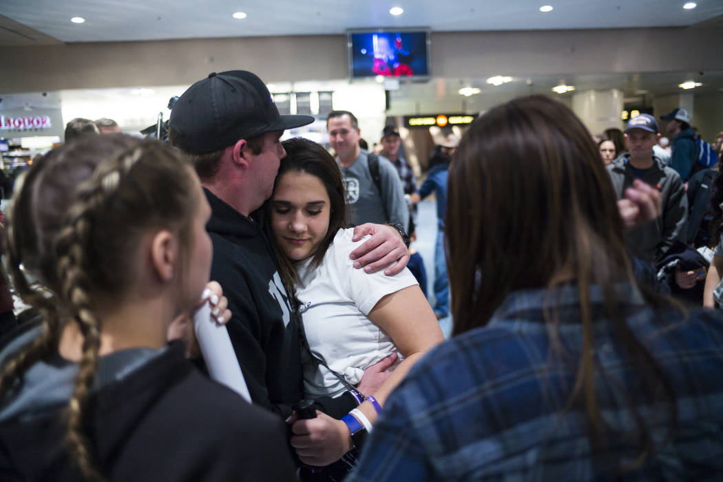 Nineteen-year-old Rylie Golgart is embraced by her boyfriend Cody Dion at McCarran International Airport in Las Vegas on Friday, Dec. 15, 2017. Golgart, a victim in the Oct. 1 shooting, spent two  ...