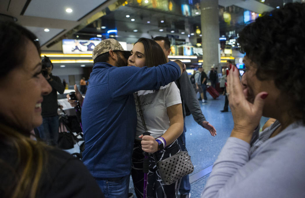 Nineteen-year-old Rylie Golgart gets a hug from her cousin Nick Bonifatto at McCarran International Airport in Las Vegas on Friday, Dec. 15, 2017. Golgart, a victim in the Oct. 1 shooting, spent t ...