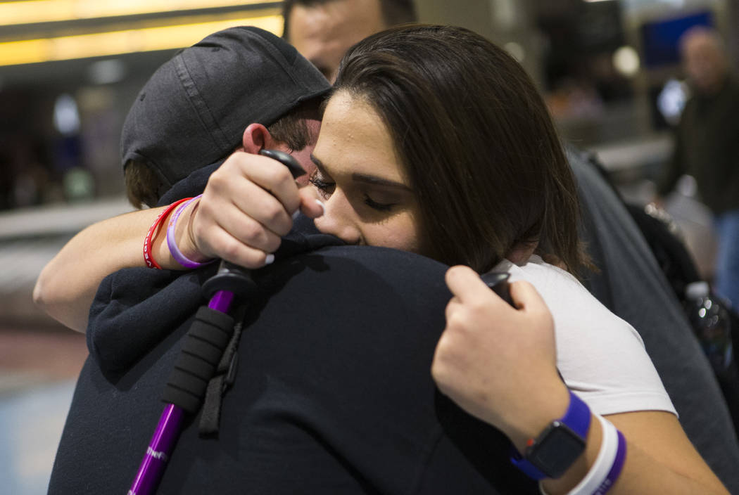 Nineteen-year-old Rylie Golgart embraces her boyfriend Cody Dion at McCarran International Airport in Las Vegas on Friday, Dec. 15, 2017. Golgart, a victim in the Oct. 1 shooting, spent two months ...