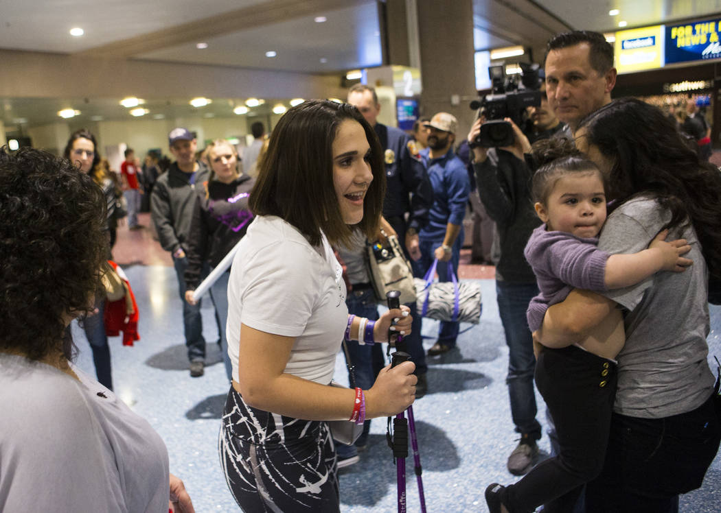 Nineteen-year-old Rylie Golgart greets her friends at McCarran International Airport in Las Vegas on Friday, Dec. 15, 2017. Golgart, a victim in the Oct. 1 shooting, spent two months in rehabilita ...