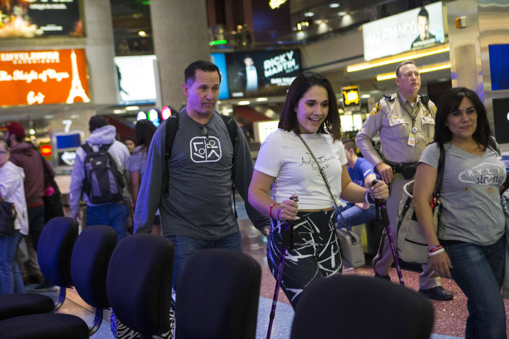 Nineteen-year-old Rylie Golgart arrives at McCarran International Airport with her parents Richard Golgart, left, and Rose Fuscaldo in Las Vegas on Friday, Dec. 15, 2017. Golgart, a victim in the  ...