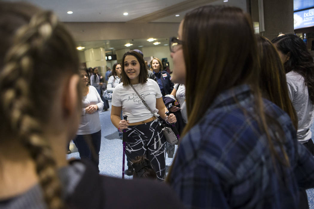 Nineteen-year-old Rylie Golgart greets her friends at McCarran International Airport in Las Vegas on Friday, Dec. 15, 2017. Golgart, a victim in the Oct. 1 shooting, spent two months in rehabilita ...