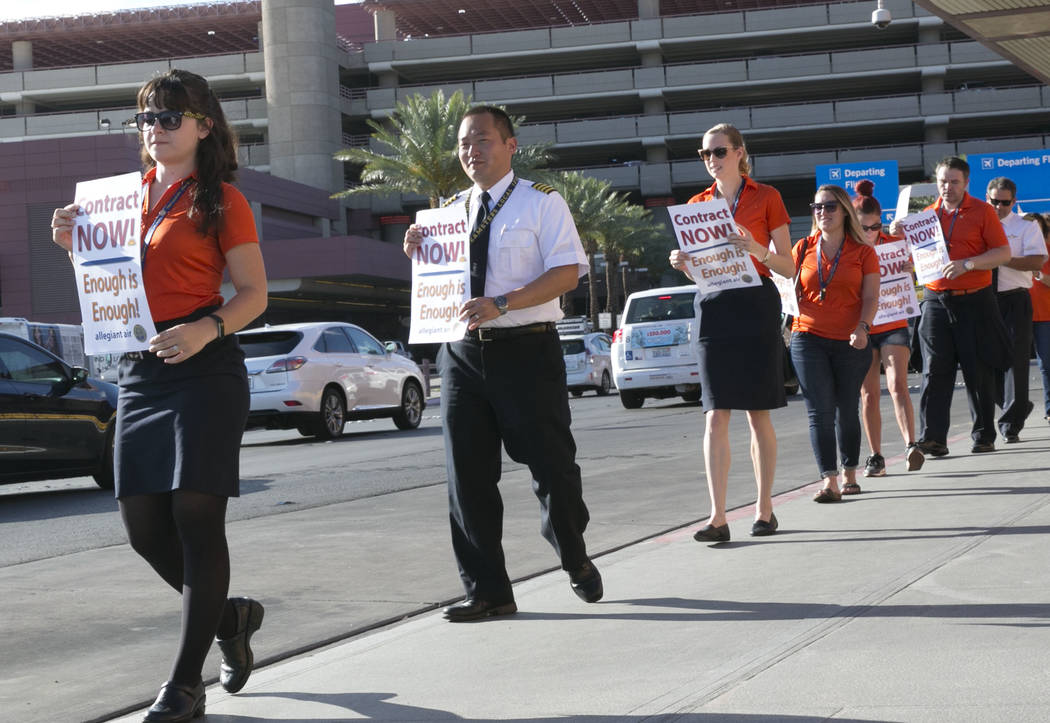 Allegiant Air flight attendants, including, from left, Elise Gordon, Alex Kim and Molly Perry picket in front of McCarran International Airport to highlight union efforts to settle a six-year cont ...