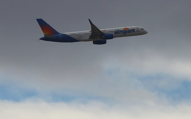 An Allegiant Air plane flies under a gray sky. Bizuayehu Tesfaye/Las Vegas Review-Journal Follow @bizutesfaye