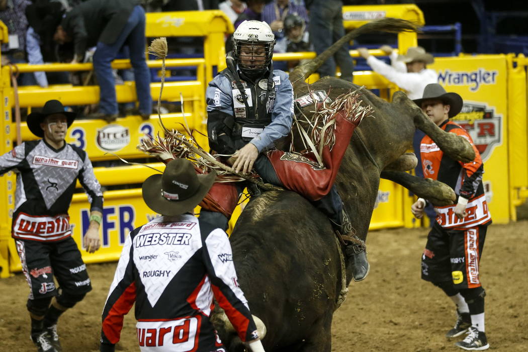 Trey Benton III of Rock Island, Texas rides Nose Bender in the bull riding competition during the ninth go-round of the National Finals Rodeo, Friday, Dec. 15, 2017, at the Thomas & Mack Cente ...