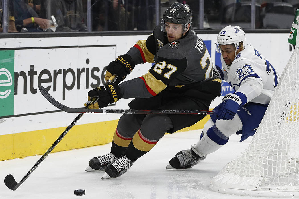 Vegas Golden Knights defenseman Shea Theodore, left, skates around Tampa Bay Lightning right wing J.T. Brown during the second period of an NHL hockey game Tuesday, Dec. 19, 2017, in Las Vegas. (A ...
