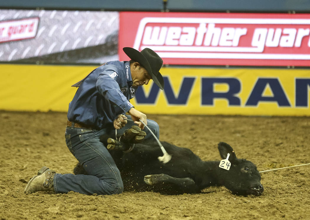 Marcos Costa of Childress, Texas takes part in the tie-down roping competition in the tenth go-round of the National Finals Rodeo, Saturday, Dec. 16, 2017, at the Thomas & Mack Center in Las V ...