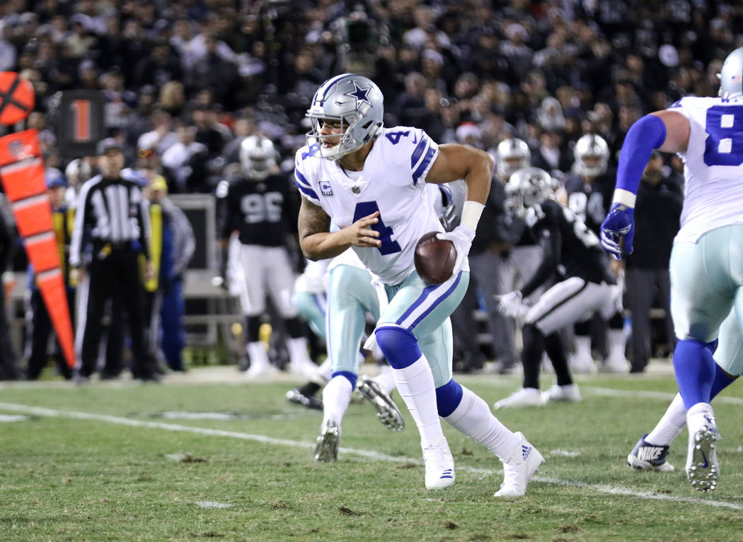Dallas Cowboys quarterback Dak Prescott (4) scrambles with the football against the Oakland Raiders during the first half of a NFL game in Oakland, Calif., Sunday, Dec. 17, 2017. Heidi Fang Las Ve ...