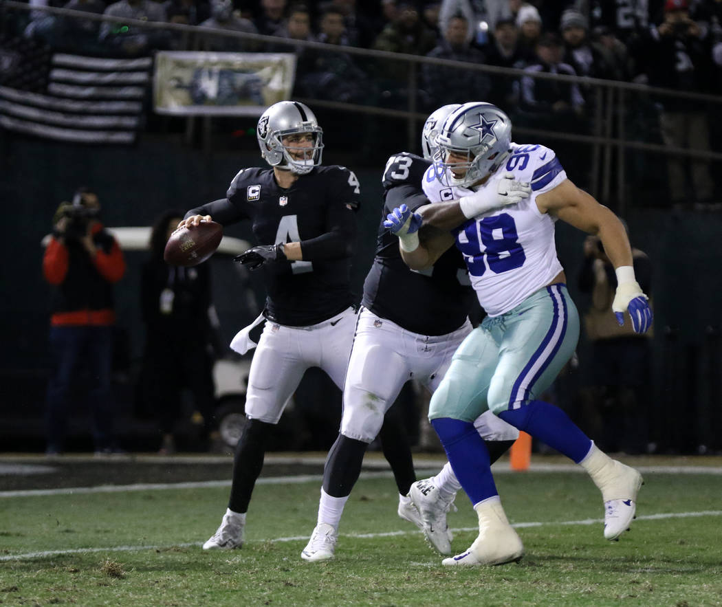 Oakland Raiders quarterback Derek Carr (4) drops back to pass as offensive tackle Marshall Newhouse (73) battles with Dallas Cowboys defensive end Tyrone Crawford (98) during the first half of a N ...