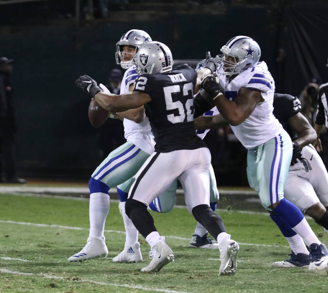 Oakland Raiders defensive end Khalil Mack (52) comes in to pressure Dallas Cowboys quarterback Dak Prescott (4) as offensive tackle Tyron Smith (77) tries to prevent a sack during the first half o ...