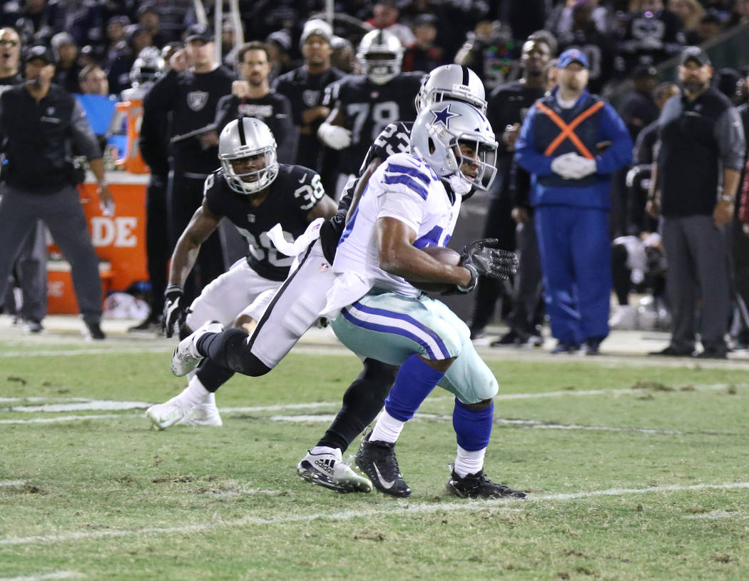 Dallas Cowboys running back Alfred Morris (46) runs past Oakland Raiders cornerback Dexter McDonald (23) during the first half of a NFL game in Oakland, Calif., Sunday, Dec. 17, 2017. Heidi Fang L ...