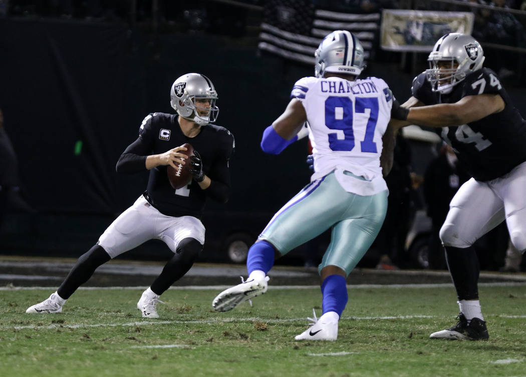Oakland Raiders quarterback Derek Carr (4) drops back to pass as offensive tackle Vadal Alexander (74) keeps Dallas Cowboys defensive end Taco Charlton (97) at bay during the first half of a NFL g ...