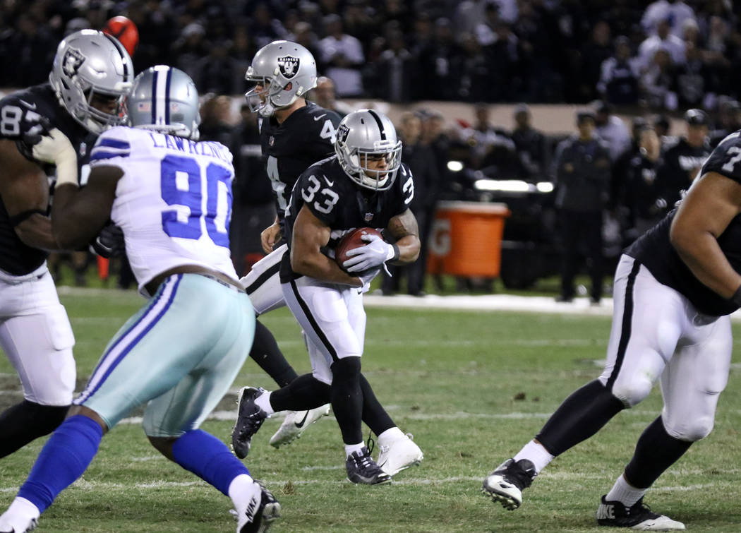 Oakland Raiders running back DeAndre Washington (33) runs with the football against the Dallas Cowboys during the first half of a NFL game in Oakland, Calif., Sunday, Dec. 17, 2017. Heidi Fang Las ...