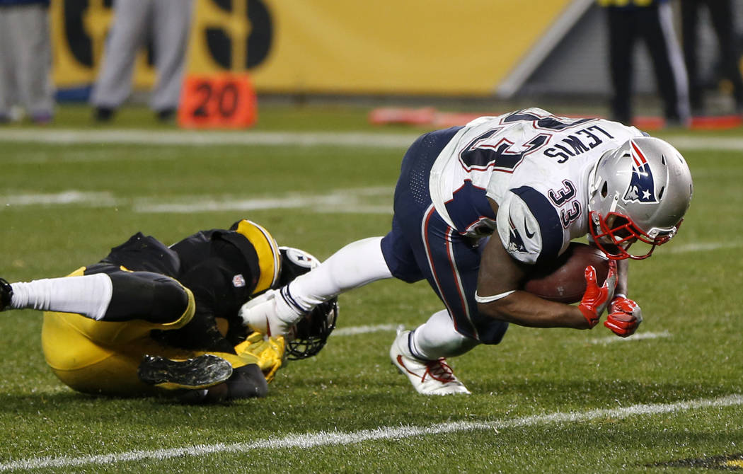 New England Patriots running back Dion Lewis (33) slips the tackle of Pittsburgh Steelers cornerback Artie Burns (25) and dives for the end zone for a touchdown during the second half of an NFL fo ...