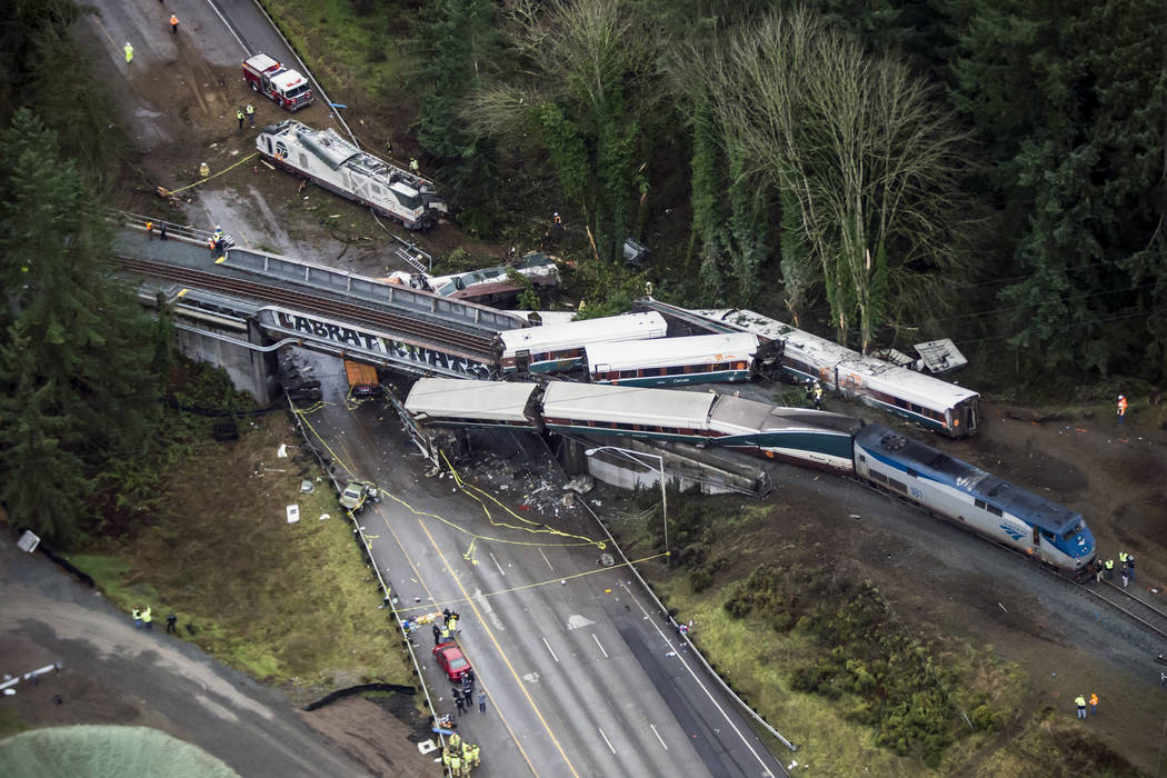 Cars from an Amtrak train that derailed lie spilled onto Interstate 5, Monday, Dec. 18, 2017, in DuPont, Wash. The Amtrak train making the first-ever run along a faster new route hurtled off the o ...