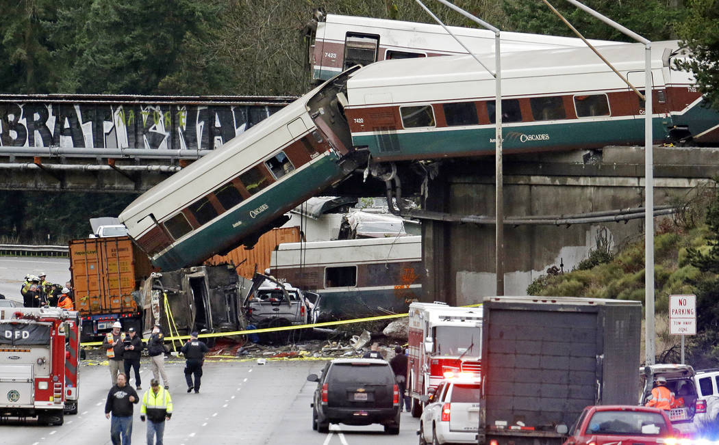 Cars from an Amtrak train lay spilled onto Interstate 5 below alongside smashed vehicles as some train cars remain on the tracks above Monday, Dec. 18, 2017, in DuPont, Wash. The Amtrak train maki ...