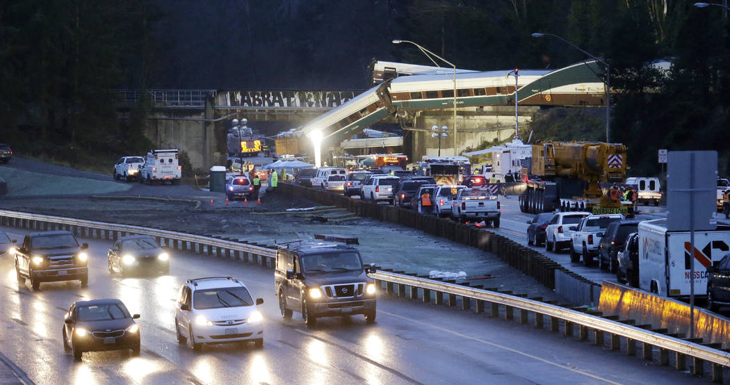 Traffic moves along northbound Interstate 5, left, as southbound lanes are filled with emergency vehicles near the scene of an Amtrak train crash Monday, Dec. 18, 2017, in DuPont, Wash. The Amtrak ...
