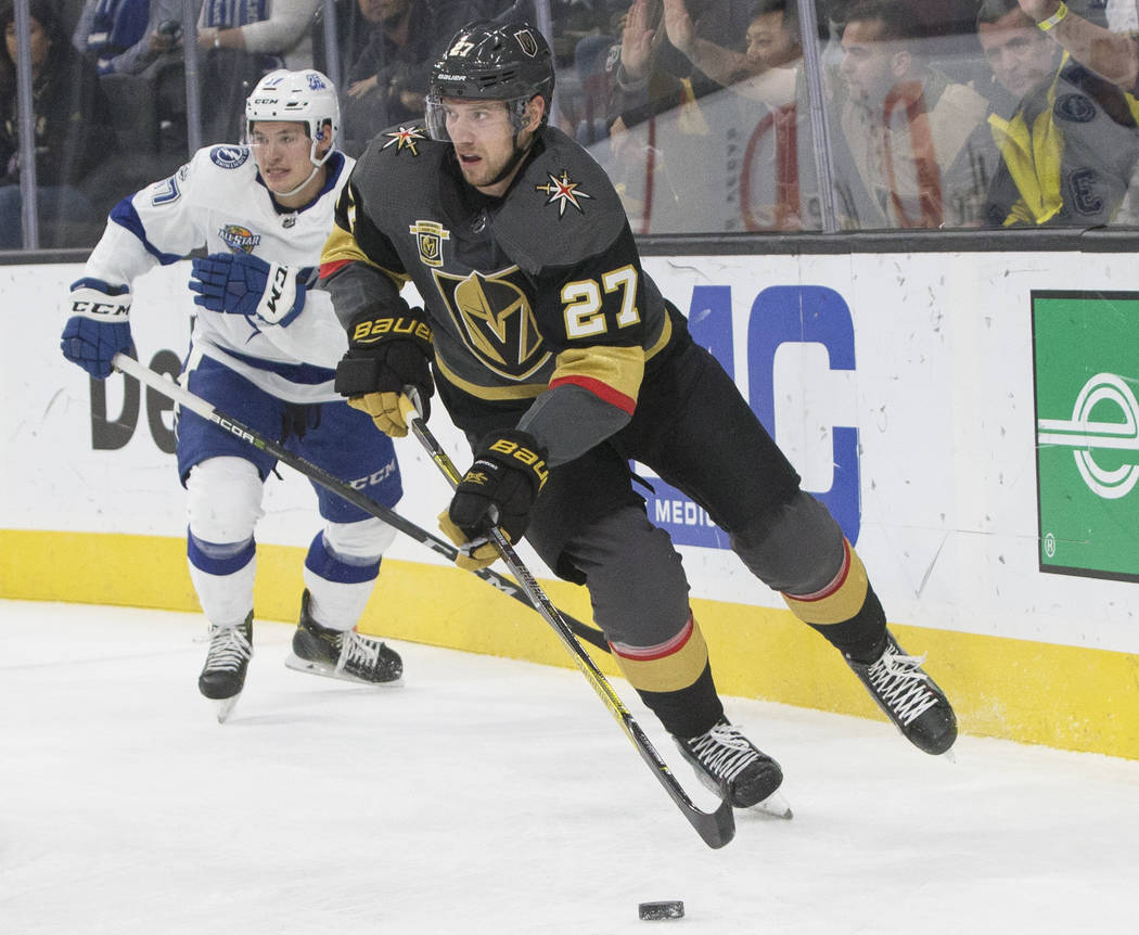 Golden Knights defenseman Shea Theodore (27) moves the puck out of the zone past Tampa Bay left wing Alex Killorn (17) in the first period during Vegas' home matchup with the Lighting on Tuesday,  ...