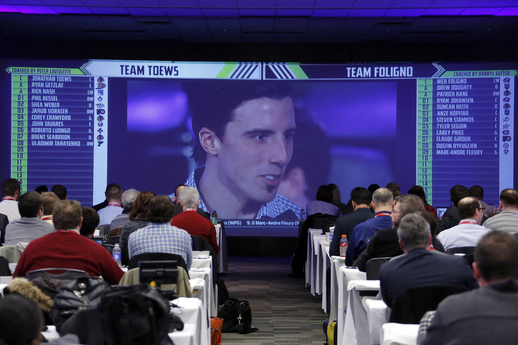 Members of the media watch on a television in a hotel ballroom as Pittsburgh Penguins goalie Marc-Andre Fleury is chosen by Team Toews during the NHL Fantasy Draft in Columbus, Ohio, Friday, Jan.  ...