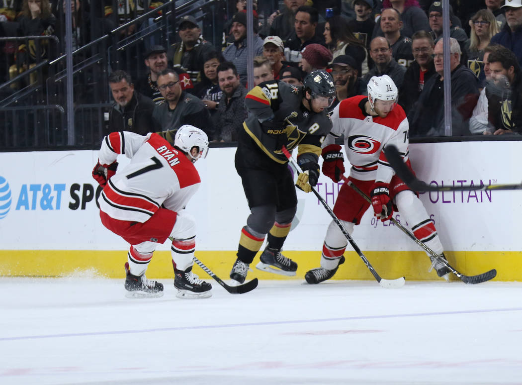 Vegas Golden Knights left wing James Neal (18) works to take the puck away from Carolina Hurricanes defenseman Jaccob Slavin (74) as center Derek Ryan (7) skates towards the action during the firs ...