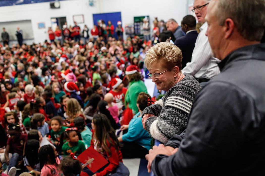 Sandy Ellis watches as students gather before handing them gifts at C. T. Sewell Elementary School in Henderson, Friday, Dec. 22, 2017. This is the 13th year that Sandy Ellis and her husband Bob E ...