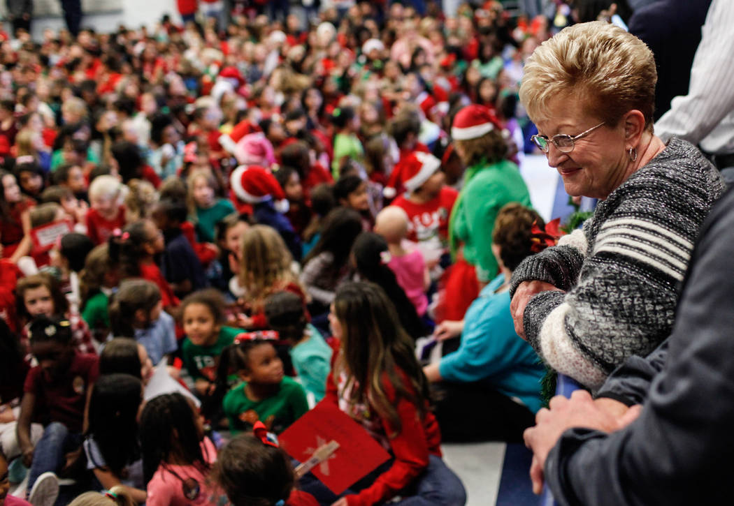 Sandy Ellis watches as students gather before handing them gifts at C. T. Sewell Elementary School in Henderson, Friday, Dec. 22, 2017. This is the 13th year that Sandy Ellis and her husband Bob E ...