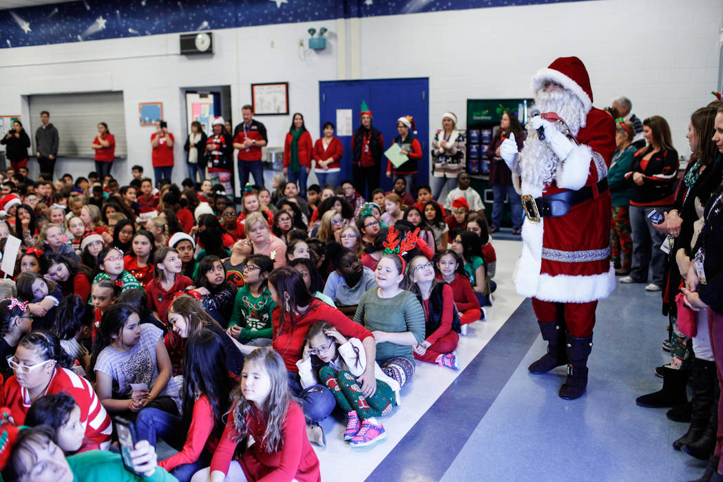 Students watch as Santa Claus speaks before handing out gifts donated by Bob and Sandy Ellis at C. T. Sewell Elementary School in Henderson, Friday, Dec. 22, 2017. This is the 13th year that the c ...