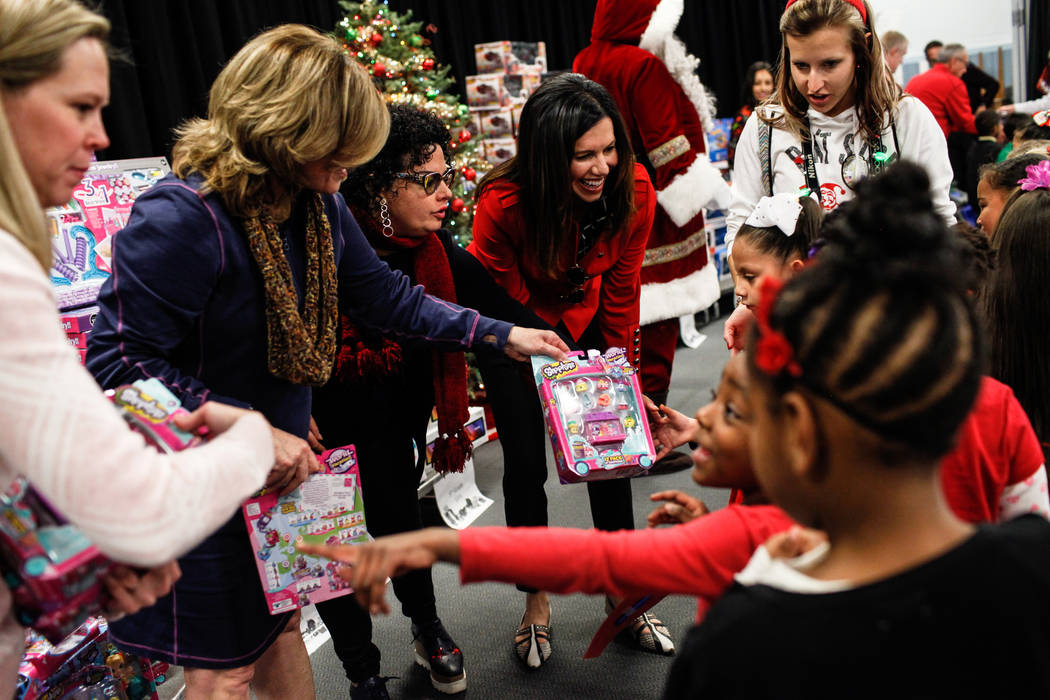 Students receive gifts donated by Bob and Sandy Ellis at C. T. Sewell Elementary School in Henderson, Friday, Dec. 22, 2017. This is the 13th year that the couple has donated gifts to underserved ...
