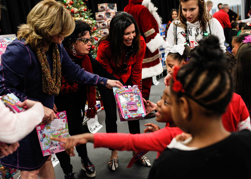 Students receive gifts donated by Bob and Sandy Ellis at C. T. Sewell Elementary School in Henderson, Friday, Dec. 22, 2017. This is the 13th year that the couple has donated gifts to underserved  ...