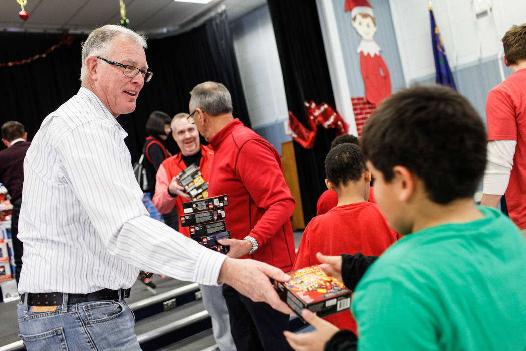 Former Henderson Mayor Andy Hafen hands out gifts donated by Bob and Sandy Ellis to students at C. T. Sewell Elementary School in Henderson, Friday, Dec. 22, 2017. This is the 13th year  ...