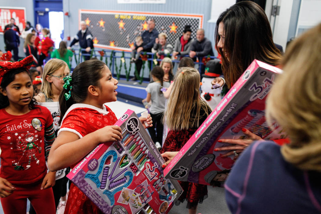UNLV Athletic Director Desiree Reed-Francois hands out gifts donated by Bob and Sandy Ellis to students at C. T. Sewell Elementary School in Henderson, Friday, Dec. 22, 2017. This is the 13th year ...