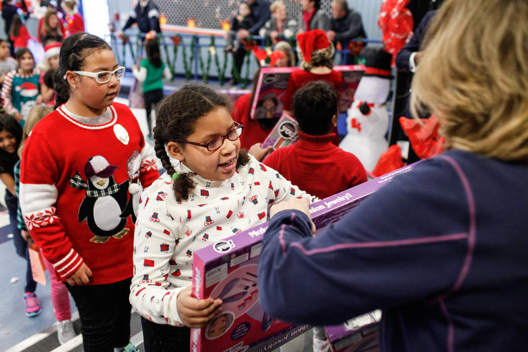 Students receive gifts donated by Bob and Sandy Ellis at C. T. Sewell Elementary School in Henderson, Friday, Dec. 22, 2017. This is the 13th year that the couple has donated gifts to underserved ...