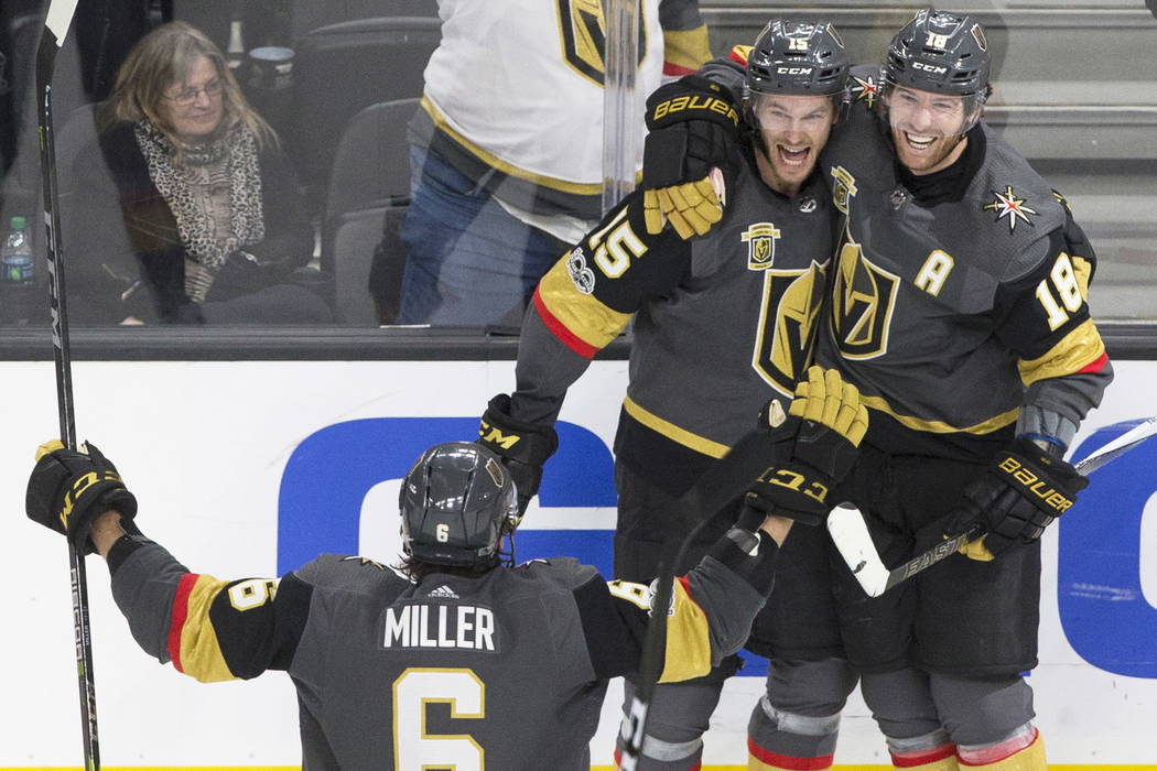 Golden Knights defenseman Jon Merrill (15) celebrates with teammates James Neal (18) and Colin Miller (6) after scoring the game winning goal in the third period during Vegas' home matchup with th ...